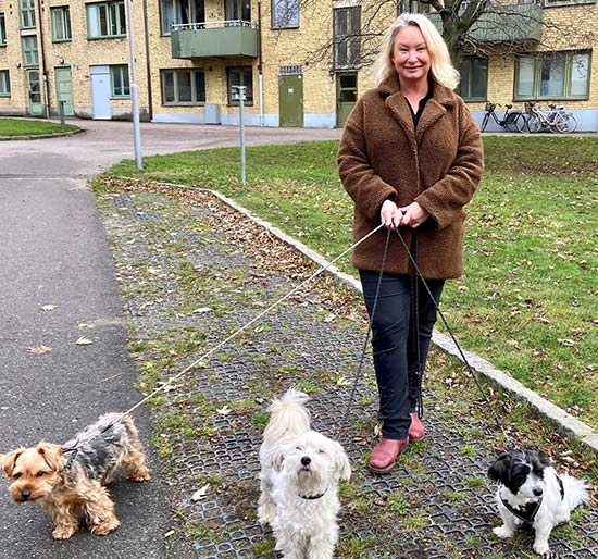 Maria som är ute och promenerar med tre små hundar.