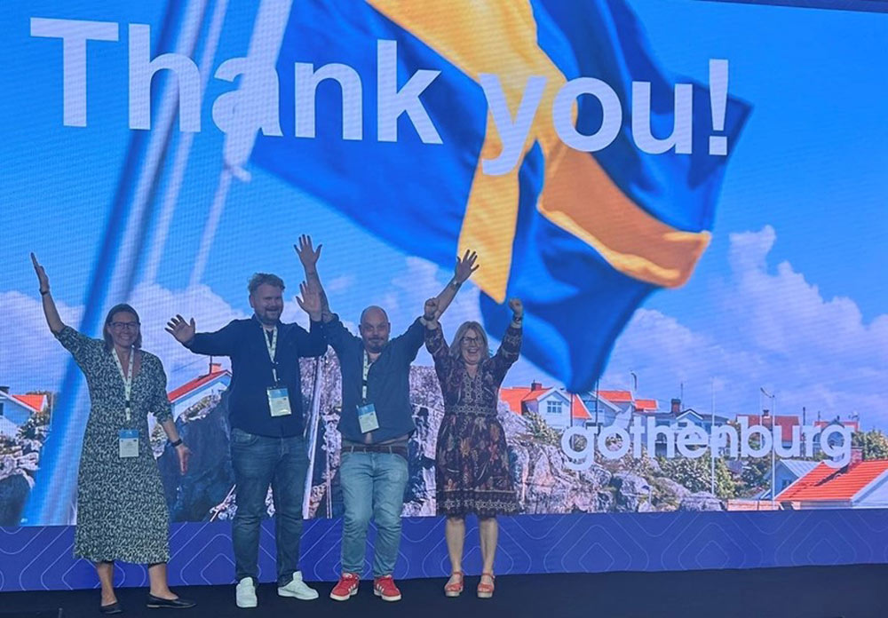 Personalen står på en scen med Göteborg i bakgrunden